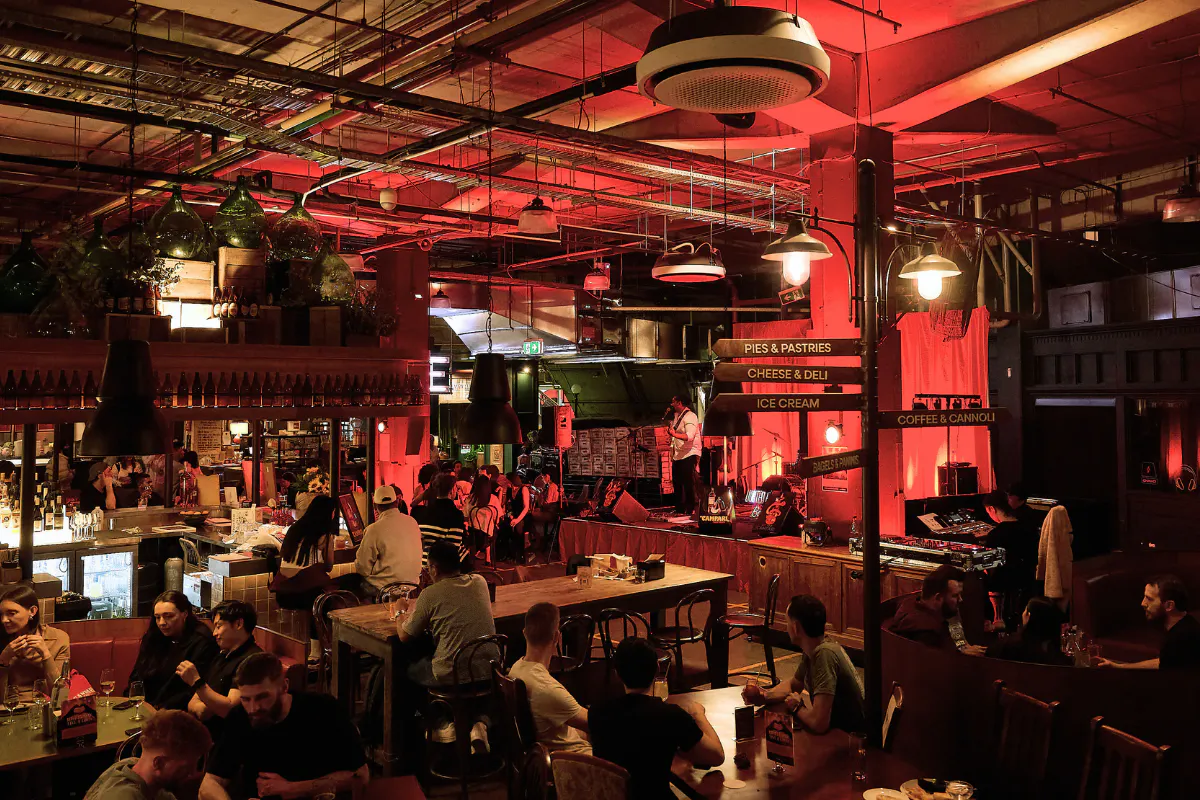 A lively, industrial style venue where guests enjoy food, drinks, and live music in a warm, energetic atmosphere.
