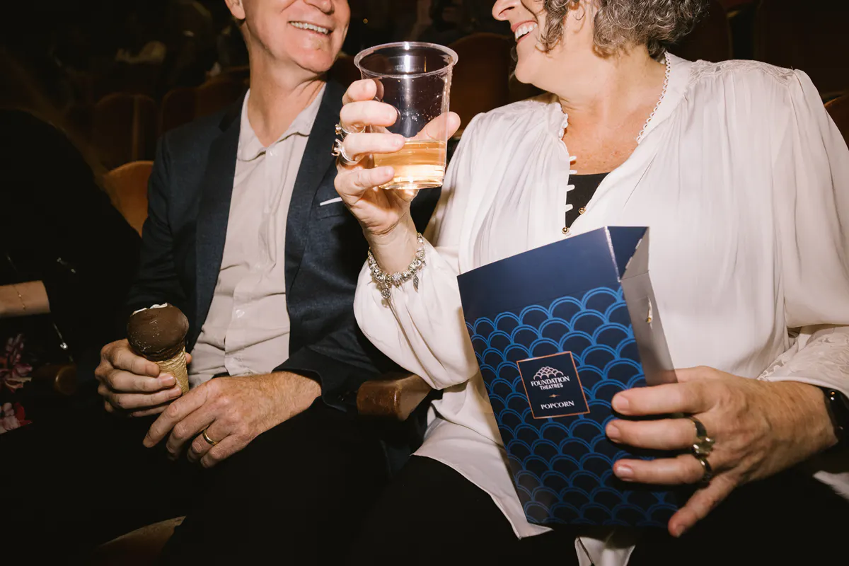 Two people share a drink and popcorn